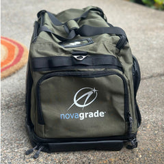 Green duffel bag with 'novagrade' logo on a concrete surface